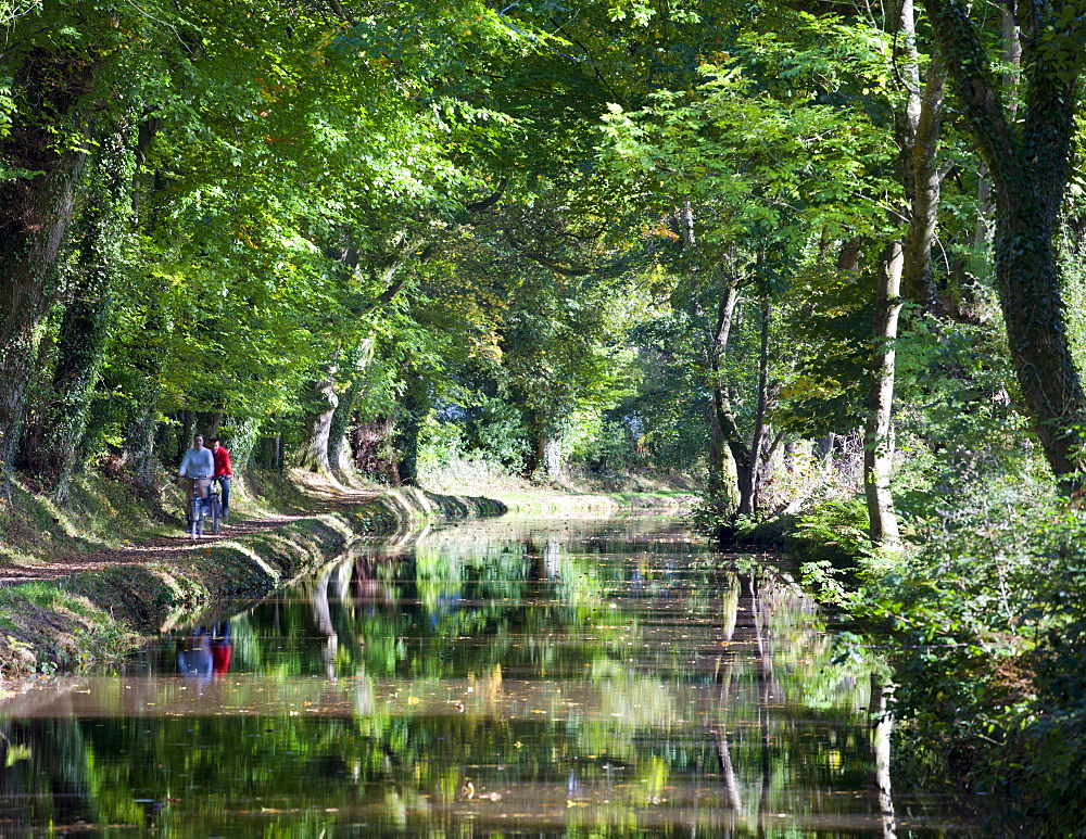 Cyclists riding along the tow path beside the Monmouthshire and Brecon Canal at Llangattock, Brecon Beacons National Park, Powys, Wales, United Kingdom, Europe