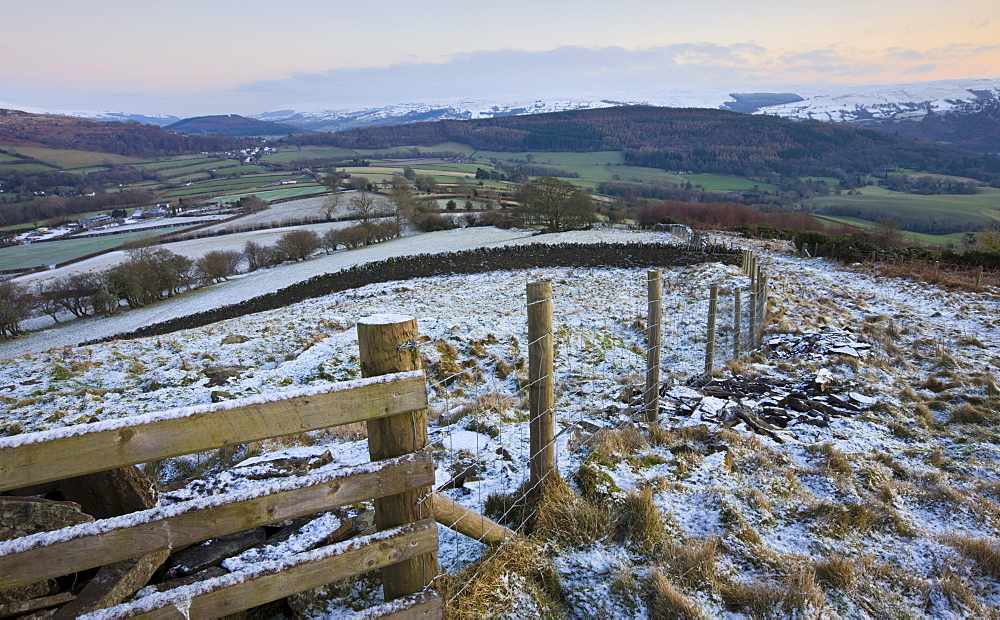 Snow dusted fence and fields looking towards Bwlch and snowy mountains beyond, Brecon Beacons National Park, Powys, Wales, United Kingdom, Europe