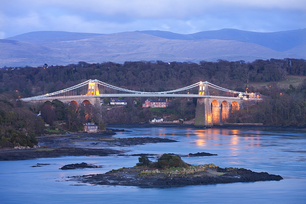 The Menai Bridge spanning the Menai Strait, backed by the mountains of Snowdonia National Park, Wales, United Kingdom, Europe