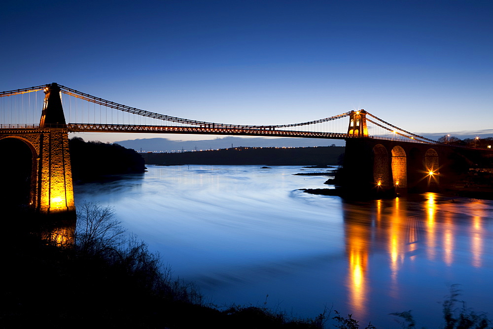 Evening illuminations on the Menai Bridge spanning the Menai Strait, Anglesey, North Wales, Wales, United Kingdom, Europe