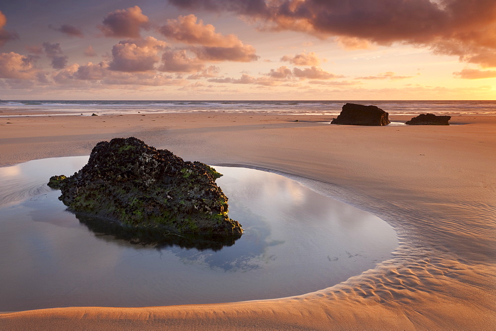 Rockpools on a deserted sandy beach at sunset, Bedruthan Steps, Cornwall, England, United Kingdom, Europe