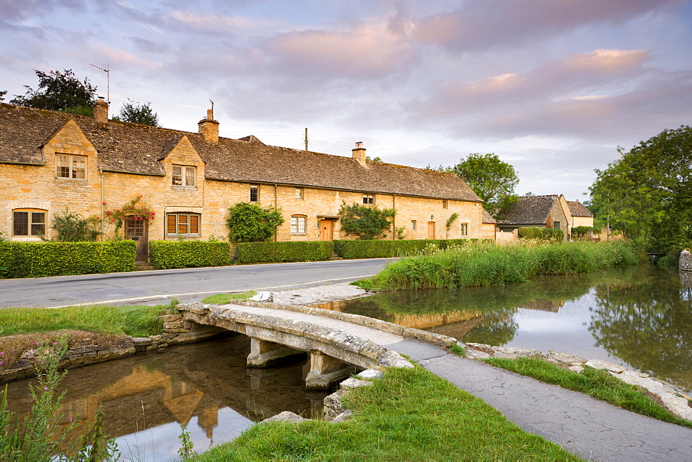 Cottages and stone footbridge in the Cotswolds village of Lower Slaughter, Gloucestershire, England, United Kingdom, Europe