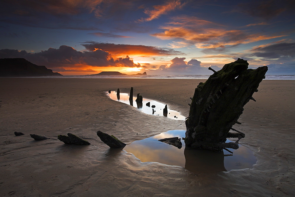 Beachside at Rhossili Bay with the wreck of the Helvetia buried in the sand, and Worm's Head on the horizon, Gower Peninsula, near Swansea, Wales, United Kingdom, Europe