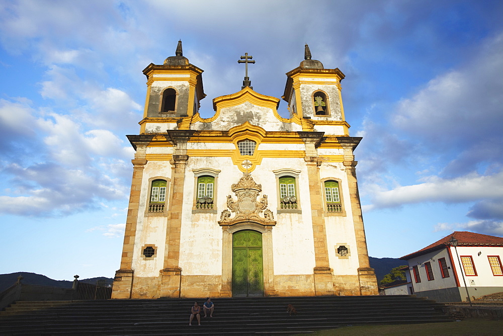 People sitting outside Sao Francisco of Assis Church in Praca Minas Gerais, Mariana, Minas Gerais, Brazil, South America 