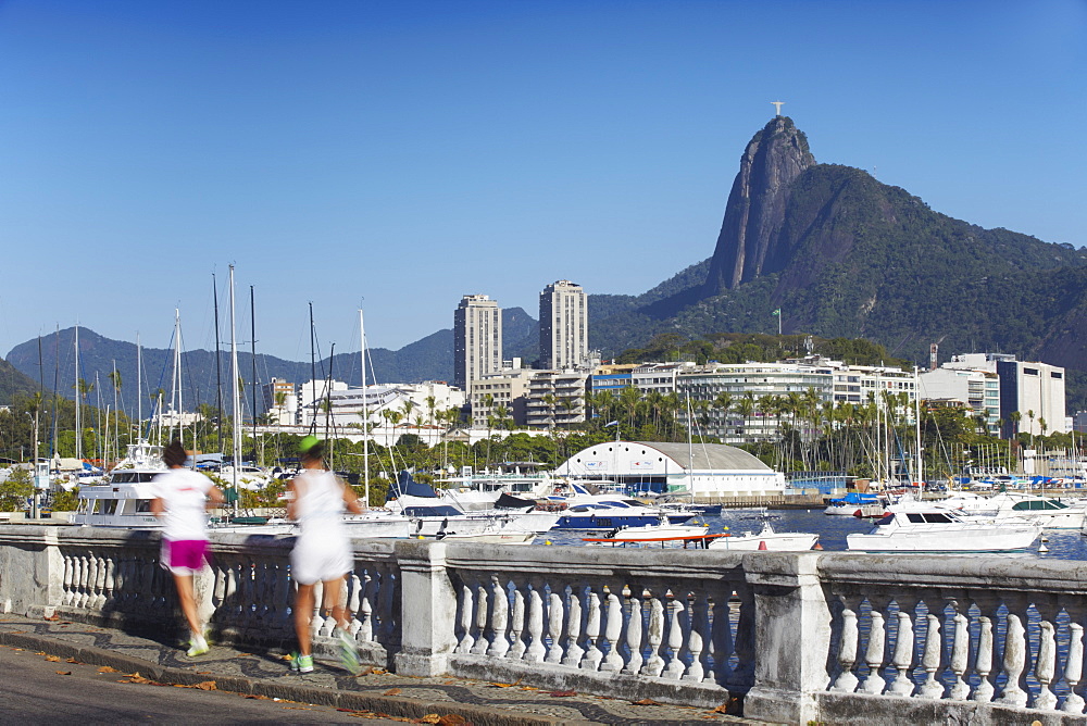 People jogging with Christ the Redeemer statue in background, Urca, Rio de Janeiro, Brazil, South America 