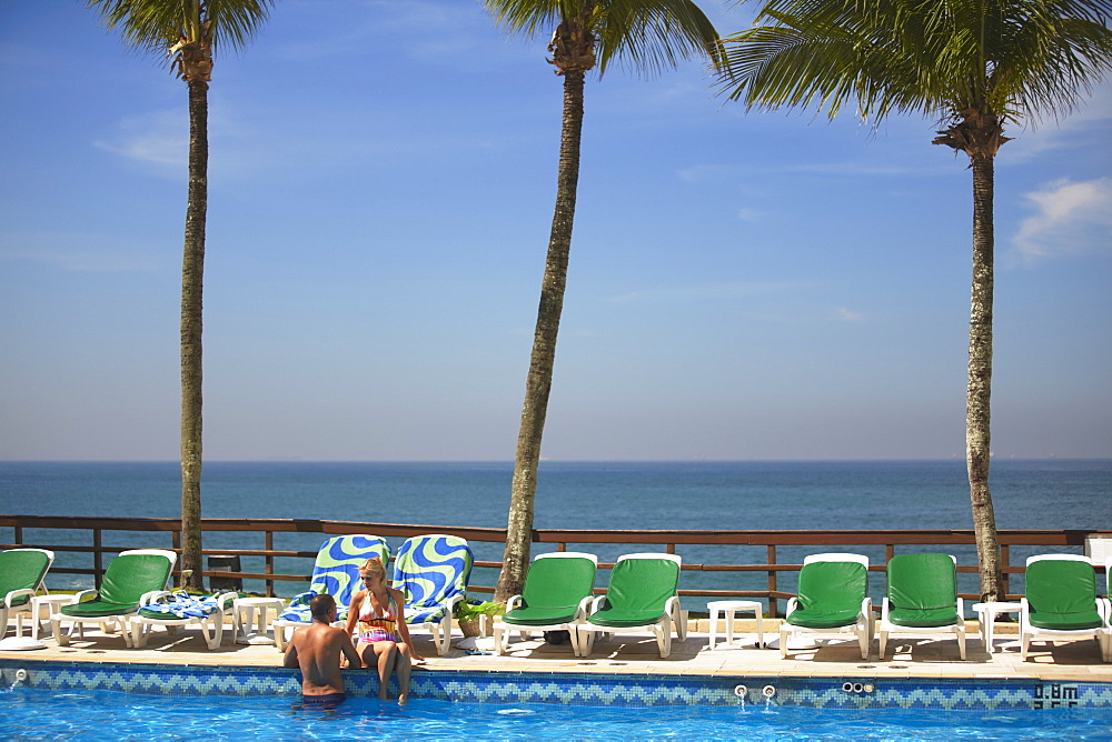 Couple relaxing by pool at Sheraton Hotel, Rio de Janeiro, Brazil, South America 