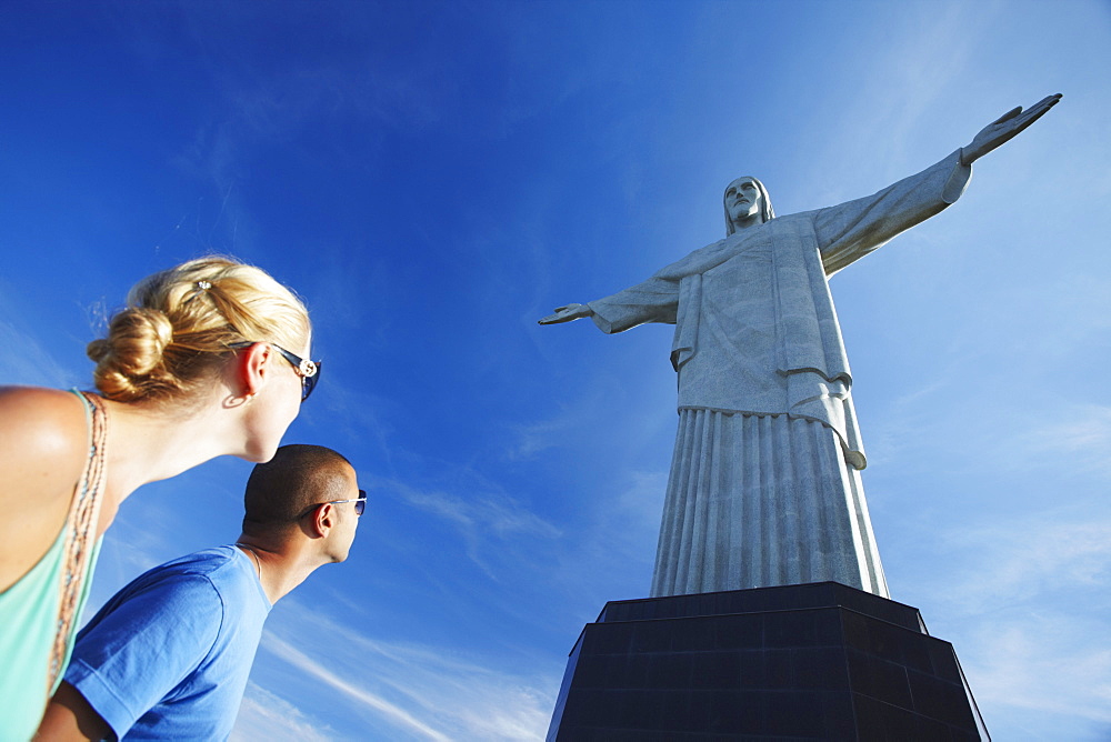 Couple at Christ the Redeemer statue (Cristo Redentor), Corcovado, Rio de Janeiro, Brazil, South America 