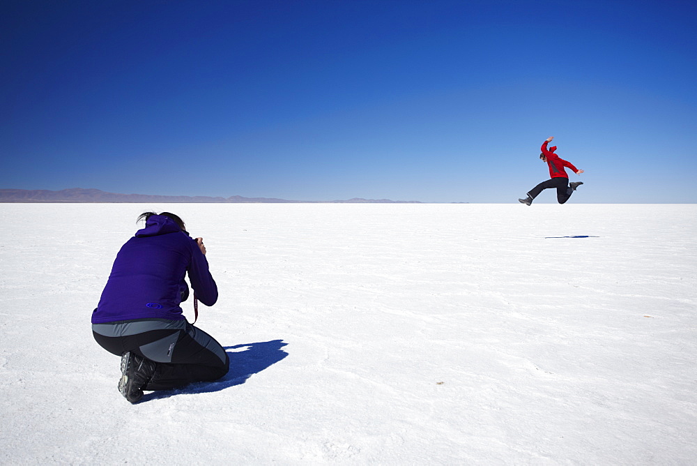 Couple taking photos on Salar de Uyuni (Salt Flats of Uyuni), Potosi Department, Bolivia, South America