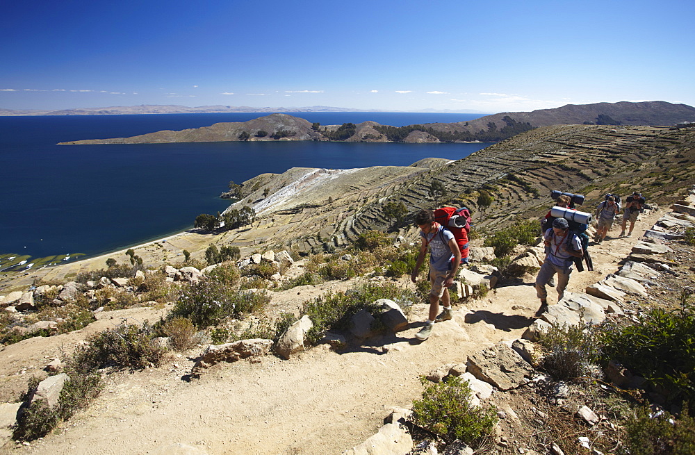 Backpackers hiking on Isla del Sol (Island of the Sun), Lake Titicaca, Bolivia, South America