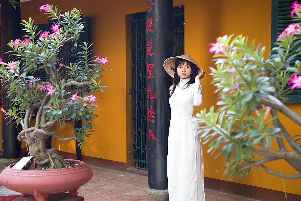 Woman wearing ao dai dress at Giac Lam Pagoda, Ho Chi Minh City, Vietnam, Indochina, Southeast Asia, Asia