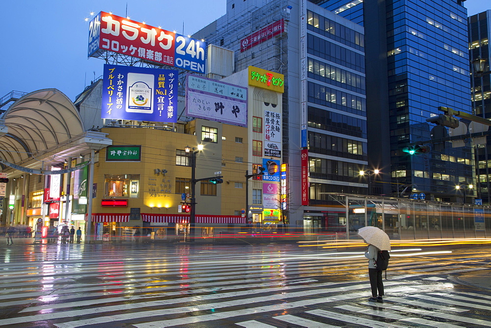 Person waiting to cross street at Hondori shopping arcade at dusk, Hiroshima, Hiroshima Prefecture, Japan, Asia