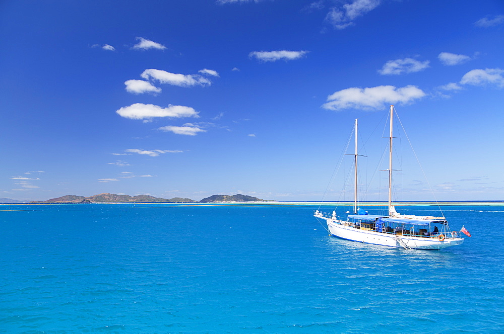 Yacht in lagoon with Malolo Island, Mamanuca Islands, Fiji, South Pacific, Pacific