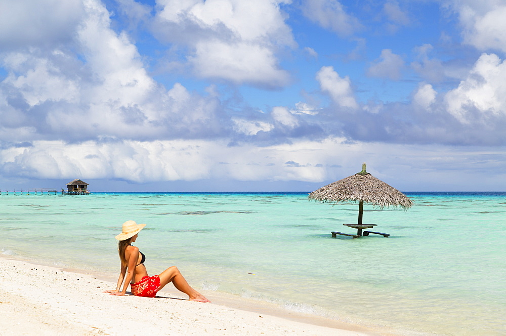 Woman sitting on beach, Fakarava, Tuamotu Islands, French Polynesia, South Pacific, Pacific