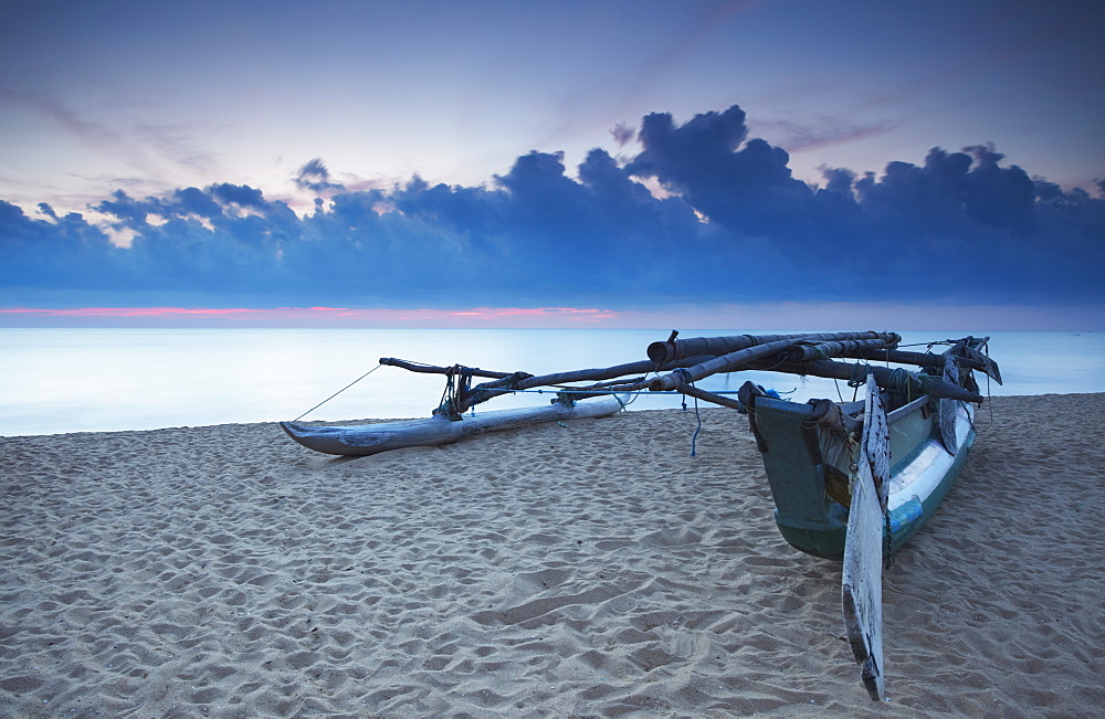 Oruwa (outrigger canoe) on beach at sunset, Negombo, North Western Province, Sri Lanka, Asia