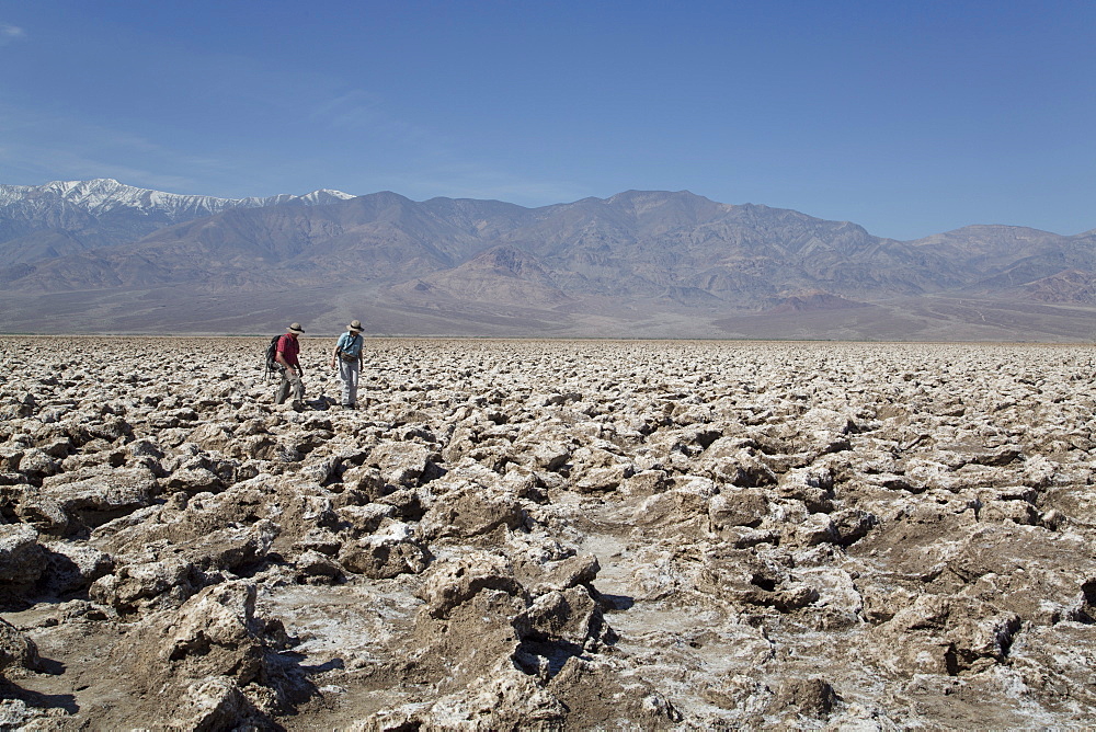 Tourists inspecting the large halite salt crystal formations, Devils Golf Course, Death Valley National Park, California, United States of America, North America