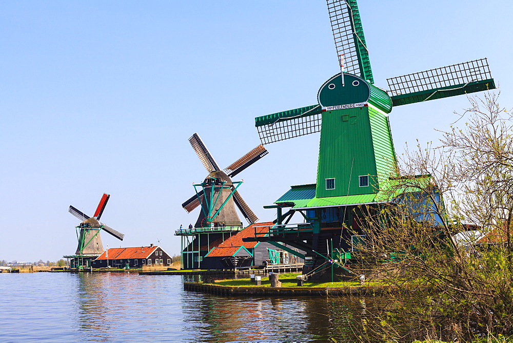 Preserved historic windmills and houses in Zaanse Schans, a village on the banks of the river Zaan, near Amsterdam, it is a popular tourist attraction and working museum, Zaandam, North Holland, Netherlands