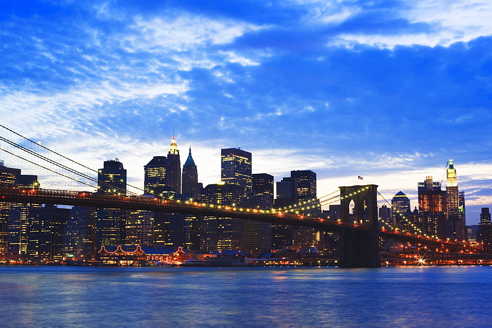 Brooklyn Bridge spanning the East River and the Lower Manhattan skyline at dusk, New York City, New York, United States of America, North America