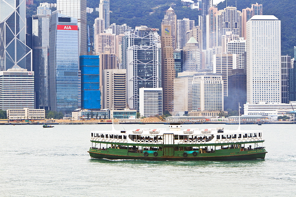 Star ferry crosses Victoria Harbour with Hong Kong Island skyline behind, Hong Kong, China, Asia