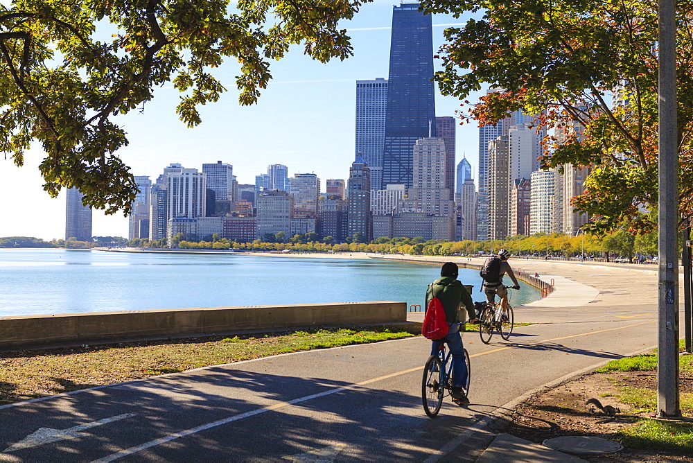 Cyclists riding along Lake Michigan shore with the Chicago skyline beyond, Chicago, Illinois, United States of America, North America