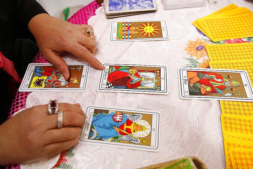 Fortuneteller laying cards on the table during a divination, Paris, France, Europe