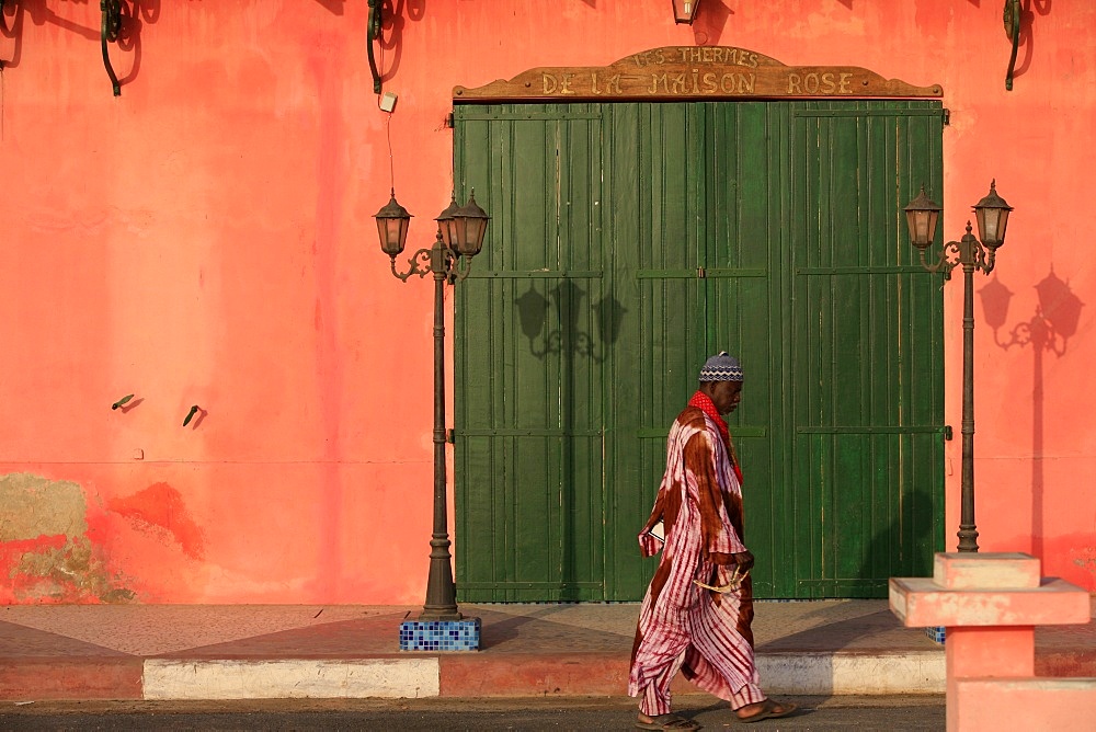 Man walking past a pink house, St. Louis, Senegal, West Africa, Africa