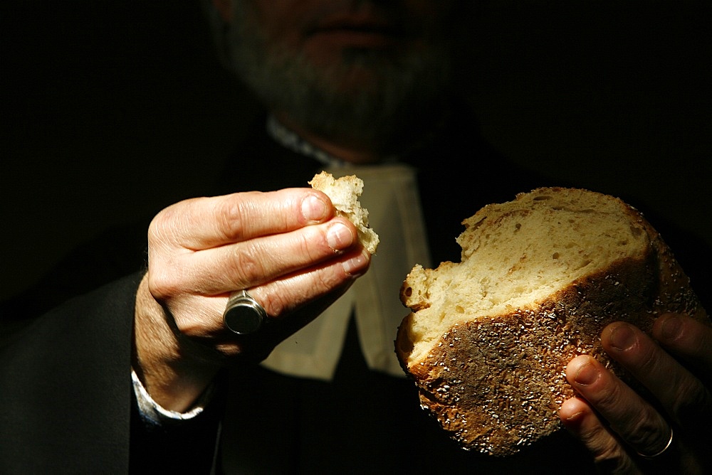 Protestant minister holding Communion bread, Geneva, Switzerland, Europe