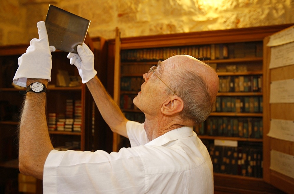 Father de Tarragon looking at photographic plates at the French Biblical and Archaeological School in Jerusalem, Israel, Middle East