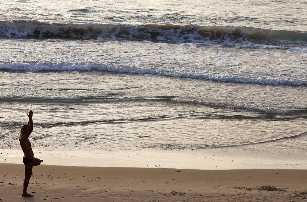 Man doing yoga on Jaffa beach, Jaffa, Israel, Middle East