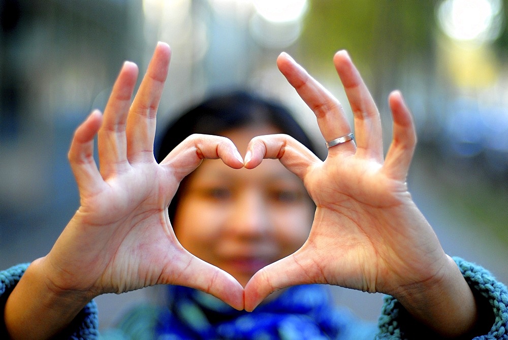 Woman making a heart with her fingers, Paris, France, Europe