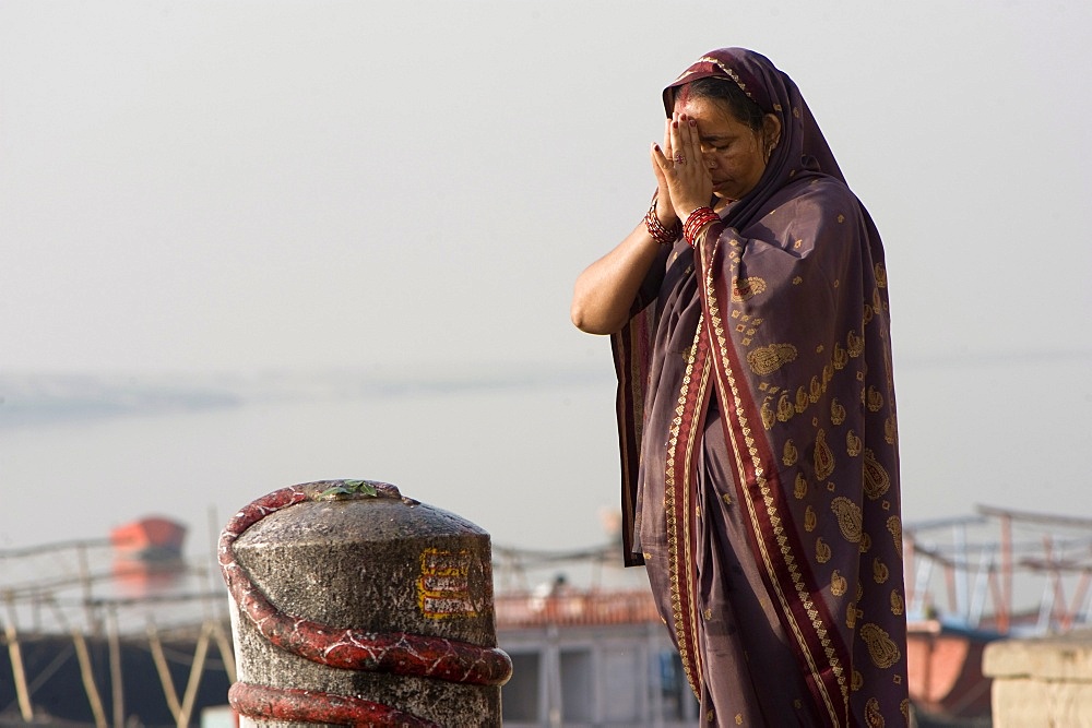 Woman praying in front of a lingam, Varanasi, Uttar Pradesh, India, Asia