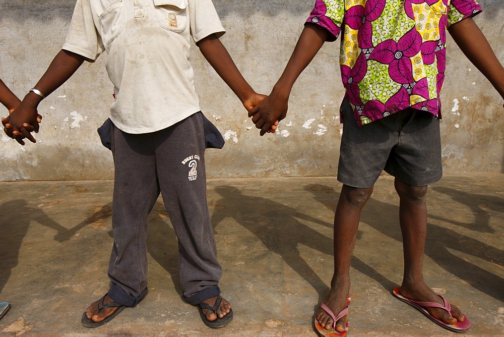 African schoolchildren holding hands, Lome, Togo, West Africa, Africa