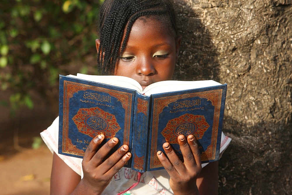 Young girl reading the Koran, Lome, Togo, West Africa, Africa