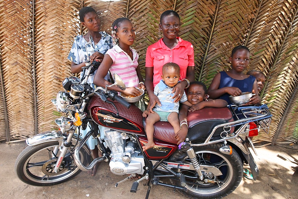 Family around a motocycle, Lome, Togo, West Africa, Africa