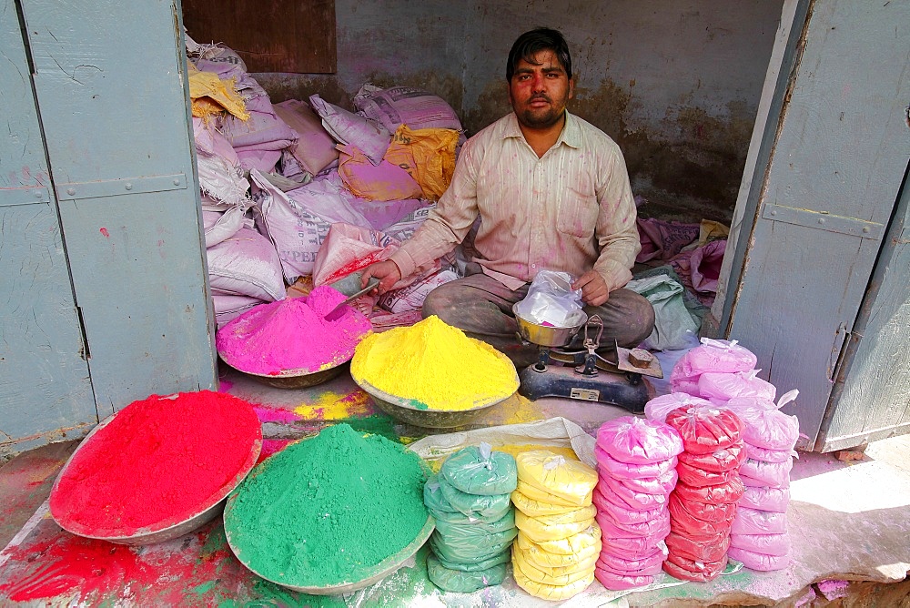 Man selling colored powders for Holi festival, Barsana, Uttar Pradesh, India, Asia