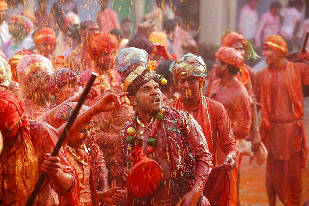 Barsana villagers celebrating Holi in Nandgaon, taunting Nandgaon villagers who throw colored fluids over them, Nandgaon, Uttar Pradesh, India, Asia