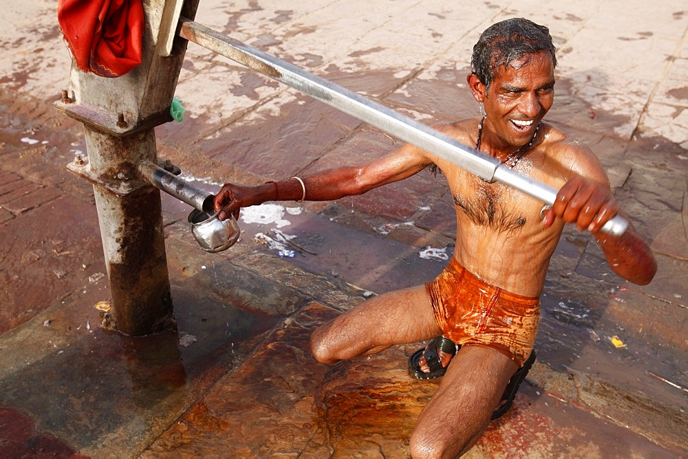 Man using a water pump for bathing, Mathura, Uttar Pradesh, India, Asia