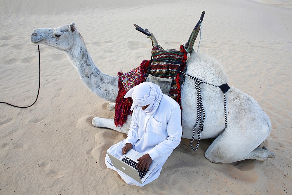 Bedouin using a laptop in the Sahara, Douz, Kebili, Tunisia, North Africa, Africa