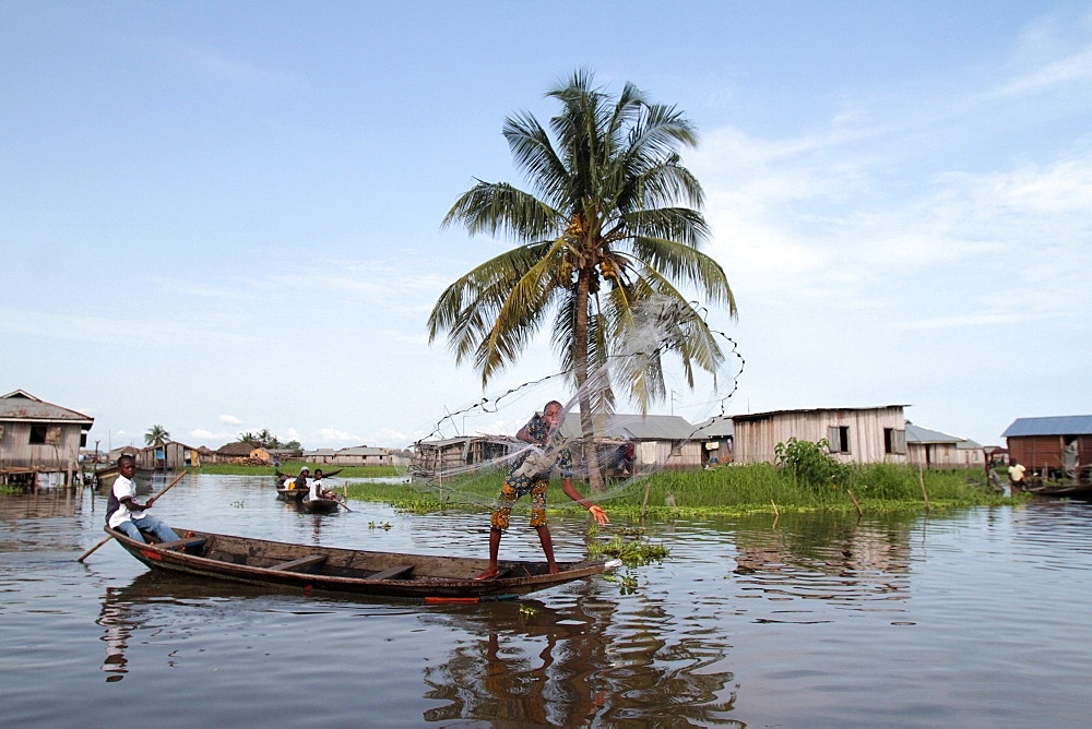 African children fishing with a net from a canoe, Lake Nokoue, Ganvie, Benin, West Africa, Africa