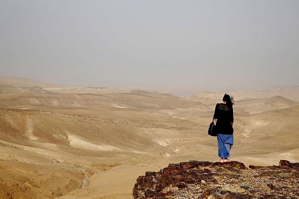 Woman praying in Judean desert during pilgrimage in the Holy Land, Israel, Middle East