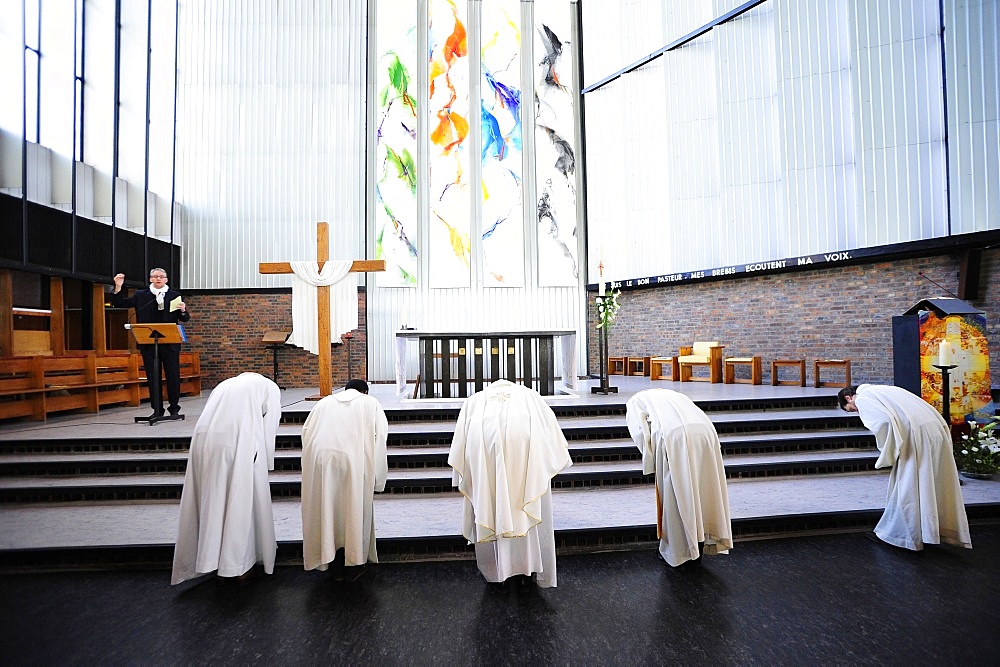 Priests leaning forward during Catholic Mass, Paris, France, Europe