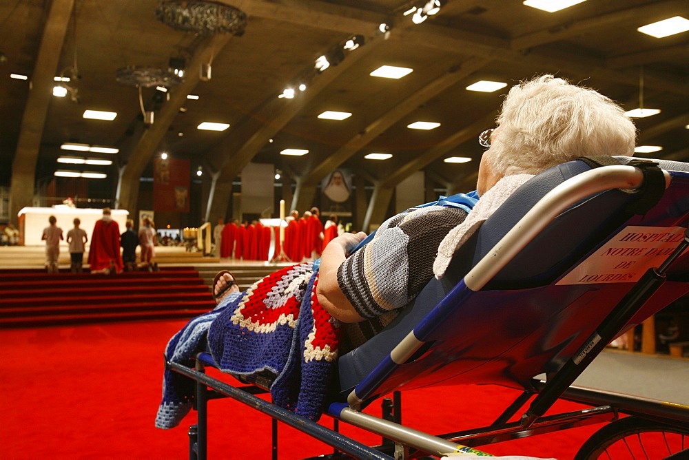 Disabled woman in the Lourdes basilica, Lourdes, Hautes Pyrenees, France, Europe