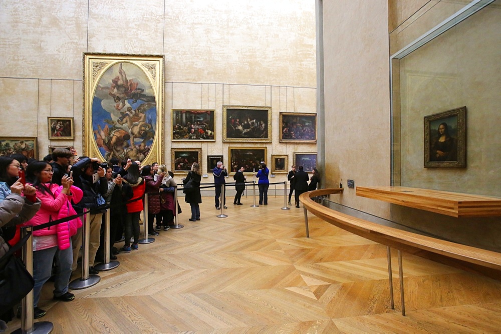 A crowd of tourists photographing the Mona Lisa portrait at the Louvre Museum, Paris, France, Euruope