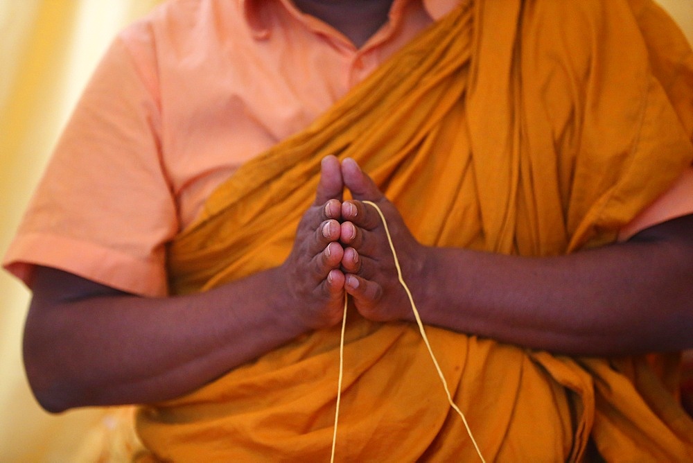 Monk praying, and Sai-Sin (sacred thread) in use in Buddhist ceremony, International Buddhist Center of Geneva, Geneva, Switzerland, Europe