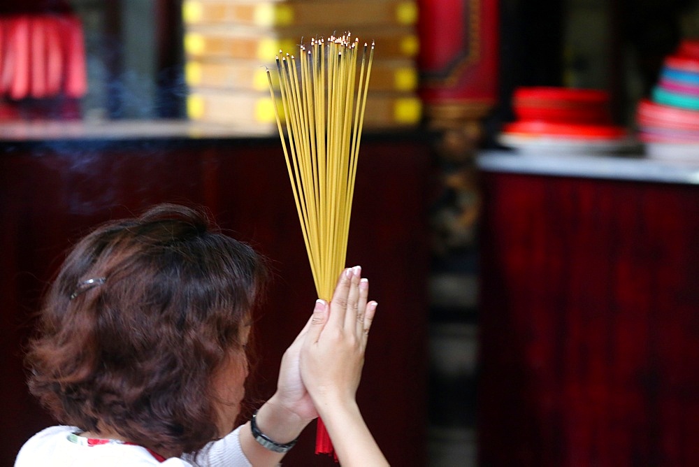 Worshipper burning incense sticks, Taoist temple, Phuoc An Hoi Quan Pagoda, Ho Chi Minh City, Vietnam, Indochina, Southeast Asia, Asia