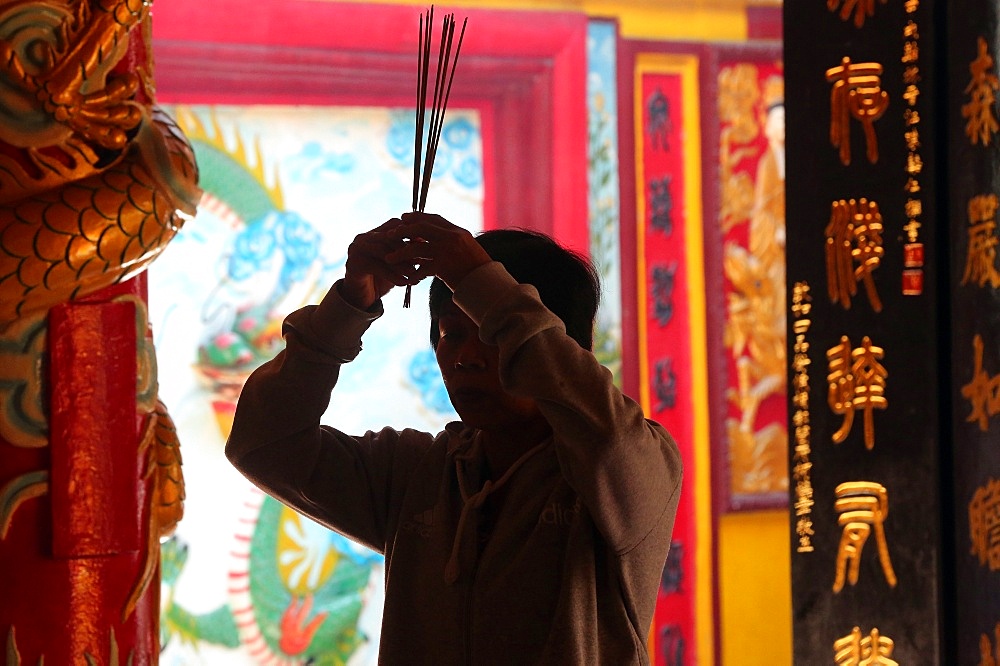 Buddhist worshipper burning incense sticks, Chua On Lang Taoist Temple, Ho Chi Minh City, Vietnam, Indochina, Southeast Asia, Asia