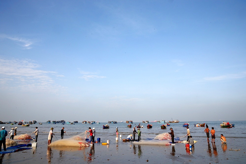 Fishing boats and women sorting fishing catch, Vung Tau Beach, Vietnam, Indochina, Southeast Asia, Asia