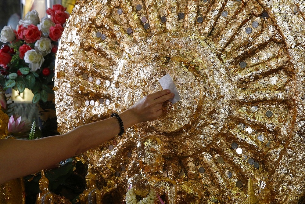 Faithful offering gold leaves in Wat Mahathat, Phetchaburi, Thailand, Southeast Asia, Asia