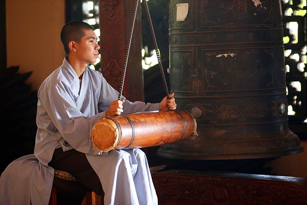 Linh An Buddhist pagoda, young monk ringing bell in monastery, Dalat, Vietnam, Indochina, Southeast Asia, Asia