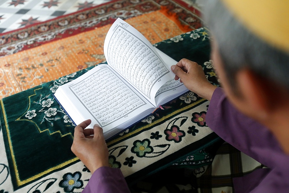 Muslim man reading an Arabic Holy Quran (Koran), Saigon Central Mosque, Ho Chi Minh City, Vietnam, Indochina, Southeast Asia, Asia