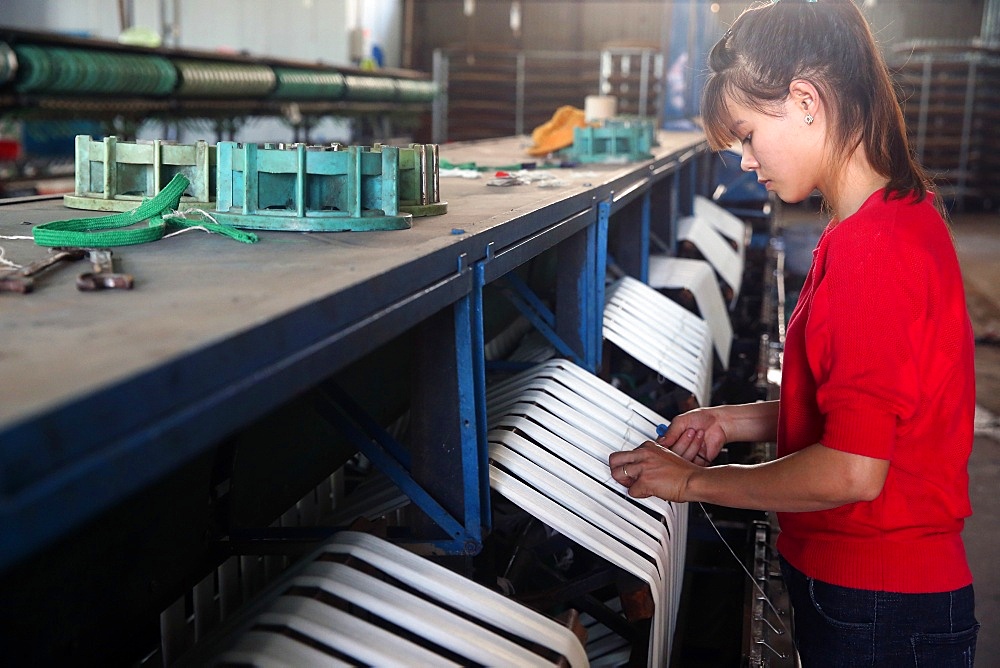 Woman working on silk spinning machine in traditional silk factory, Dalat, Vietnam, Indochina, Southeast Asia, Asia